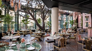 A luxurious dining area with round tables, elegant chairs, and a large tree centerpiece. - Flamingo Las Vegas Hotel & Casino (Las Vegas)