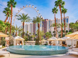 A hotel pool with a Ferris wheel, palm trees, and modern buildings in the background. - Flamingo Las Vegas Hotel & Casino (Las Vegas)
