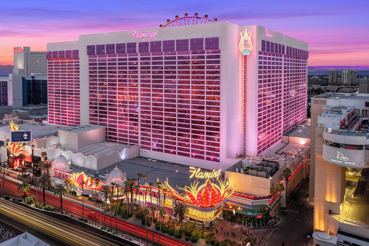 A large hotel with a prominent Flamingo sign, multiple floors, and a casino area with bright lights and palm trees.