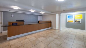 A reception area with a wooden counter, recessed lighting, and a tiled floor. - Days Inn by Wyndham Casper (Casper)