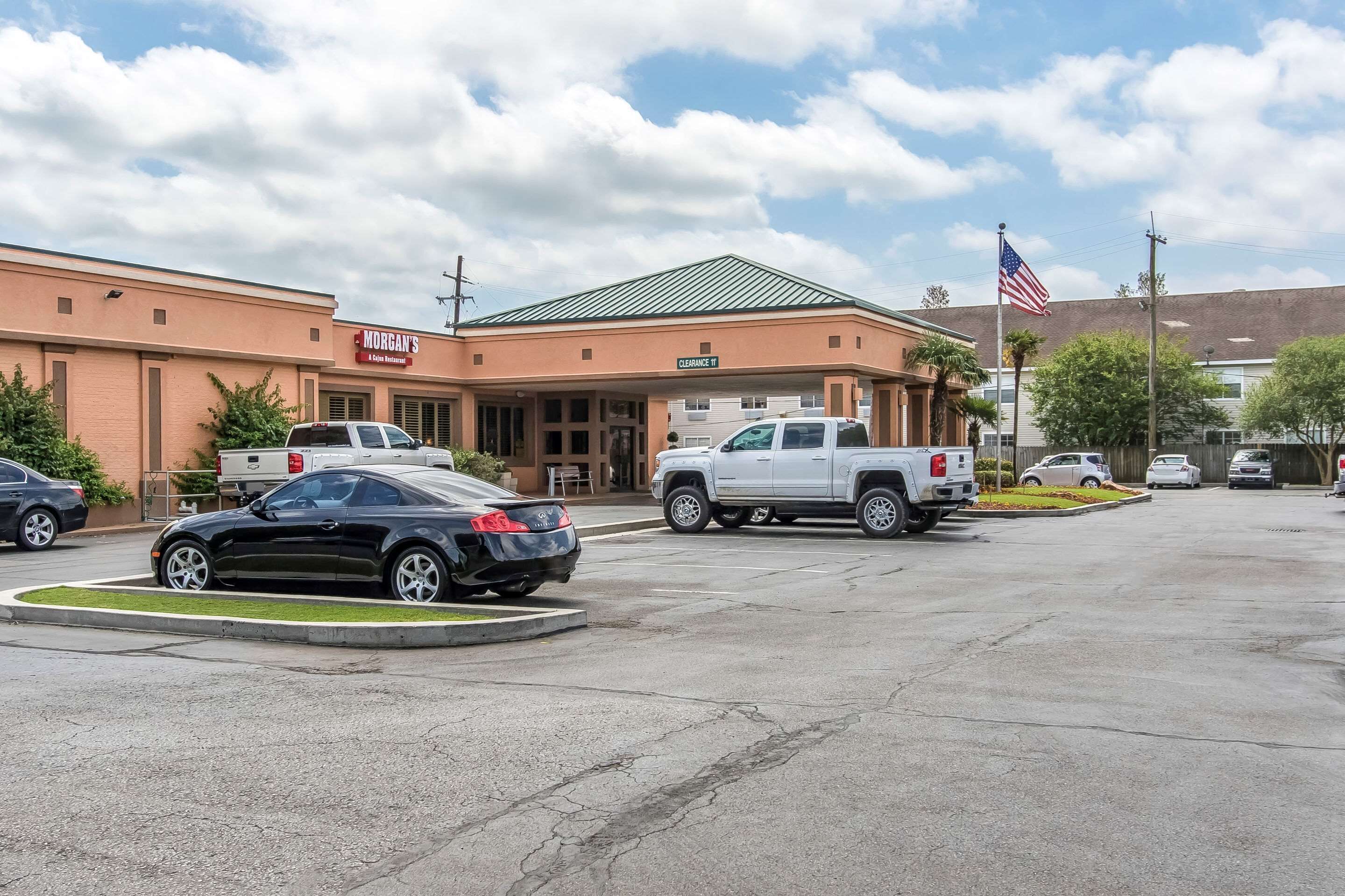 A parking lot with a building labeled "Morgan's 4th of July Inn" and an American flag.