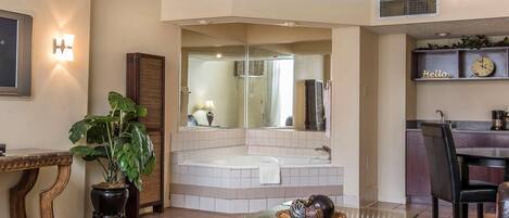 A modern bathroom with a freestanding bathtub, a large mirror, and a vanity with a sink.