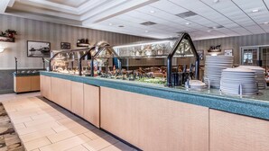 A buffet area with a counter, food display, and seating area. - Clarion Inn Morgan City (Morgan City)