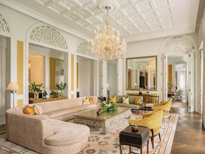 A spacious living room with a large sectional sofa, a coffee table, and a chandelier.
