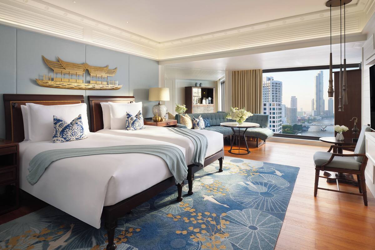 Amplia habitación de hotel con una cama grande, zona de estar y vistas a la ciudad.