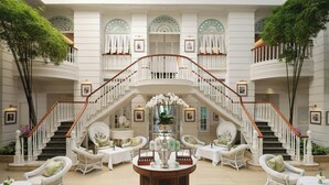 A grand hotel lobby with a central staircase, multiple seating areas, and a large decorative table. - Mandarin Oriental, Bangkok (Bangkok)