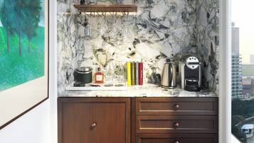A kitchen with marble backsplash, wooden cabinets, and a coffee machine.