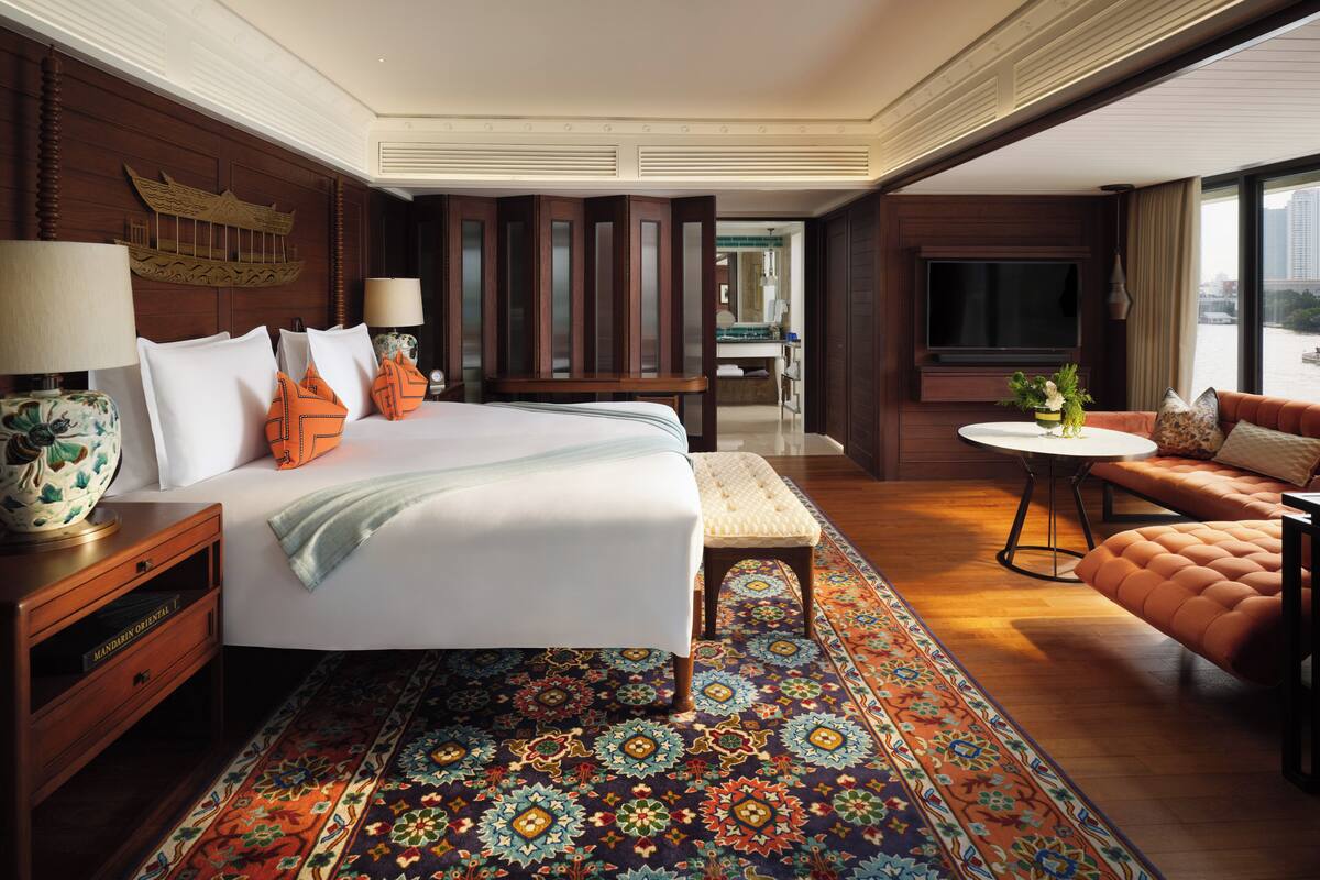 Habitación de hotel con una cama grande, un sofá, una pequeña mesa y un televisor.