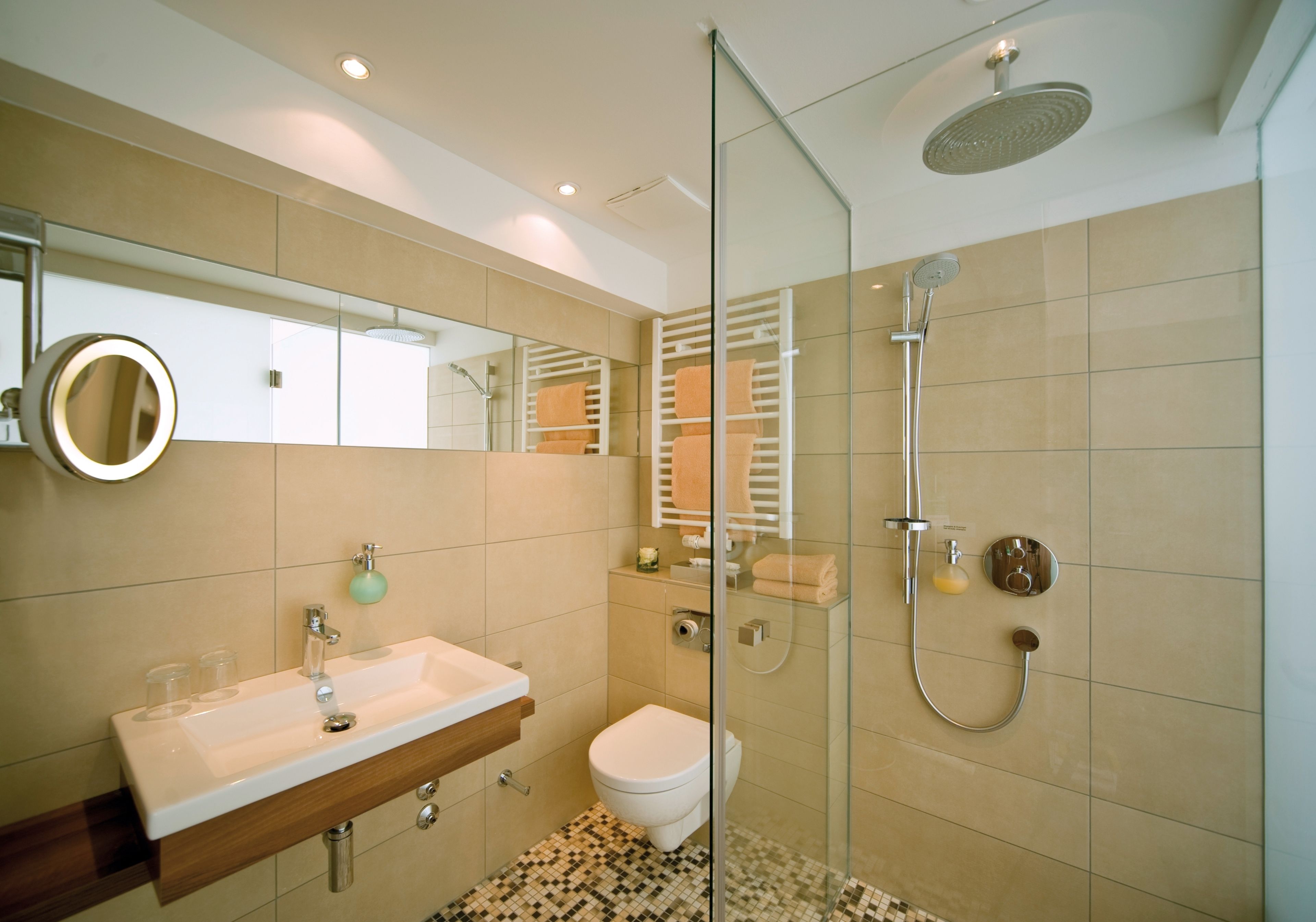 Une salle de bain moderne avec une douche à parois de verre, un lavabo blanc et des toilettes.