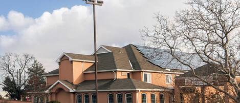 A two-story house with a sloped roof, a street lamp, and a fence in the foreground.