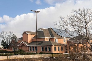 Uma casa de dois andares com telhado inclinado, um poste de luz e uma cerca em primeiro plano.