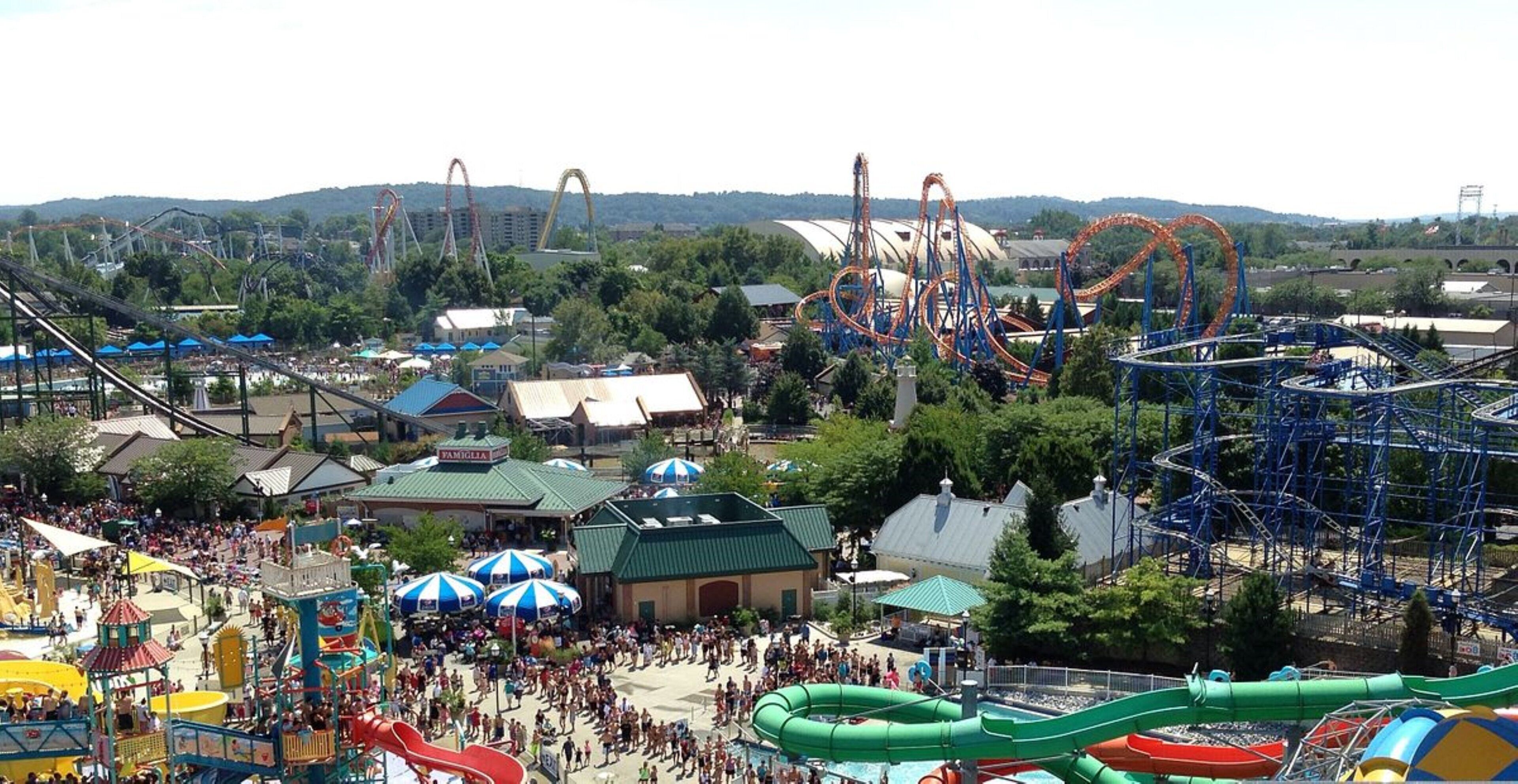 Un parc d’attractions avec des montagnes russes, un parc aquatique et une foule de visiteurs.