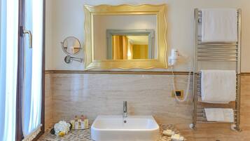 Un bagno con uno specchio grande, un lavandino, un portasciugamani e uno spazio doccia.