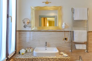 A bathroom with a large mirror, a sink, a towel rack, and a shower area. - Hotel Savoia e Jolanda, WorldHotels Elite (Venice)