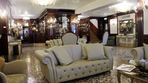 A luxurious lobby with a plush sofa, elegant chandeliers, and a grand staircase. - Hotel Savoia e Jolanda, WorldHotels Elite (Venice)