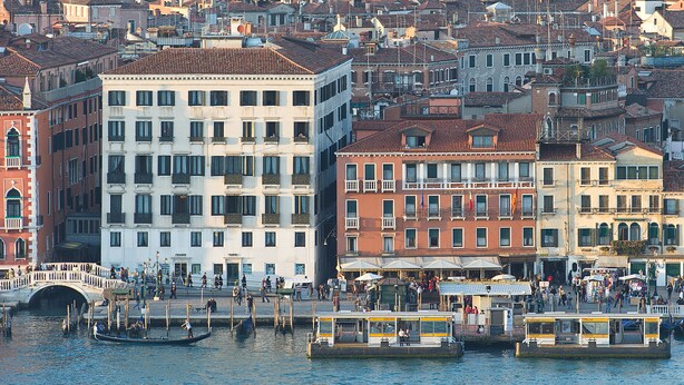 A canal with gondolas and a bridge, surrounded by historic buildings with balconies and shops. - Hotel Savoia e Jolanda, WorldHotels Elite (Venice)