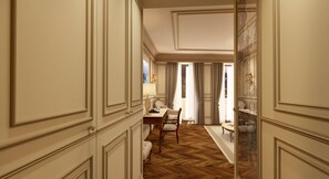 A hallway with a wooden herringbone floor, white paneled walls, and a dining area with a table and chairs. - Hotel Savoia e Jolanda, WorldHotels Elite (Venice)