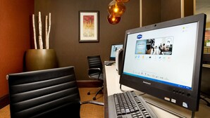 A hotel room with a desk, a laptop, a keyboard, a chair, and a vase with sticks. - Hampton Inn Haverhill (Haverhill)