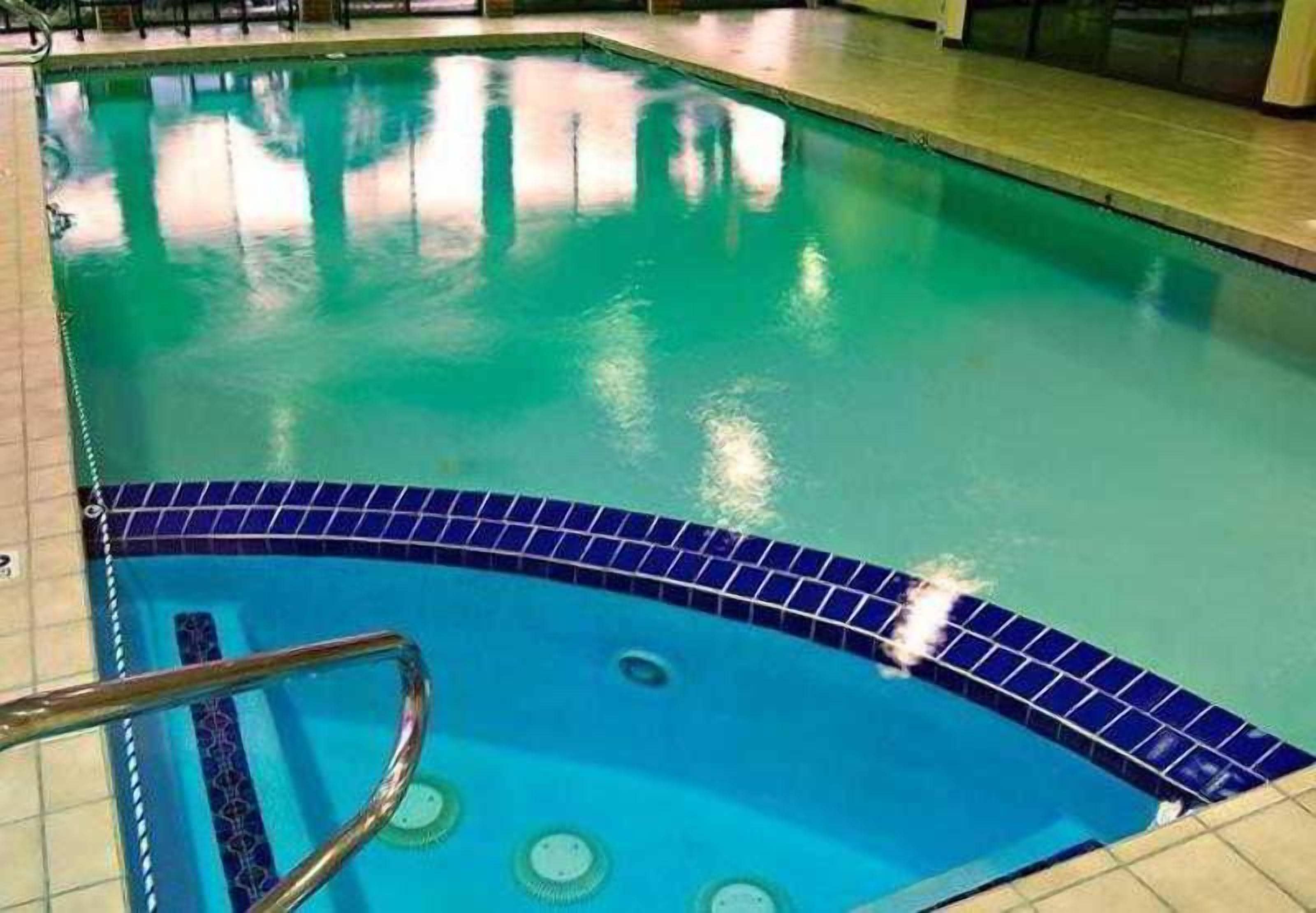 A swimming pool with a blue tiled edge and a metal ladder.