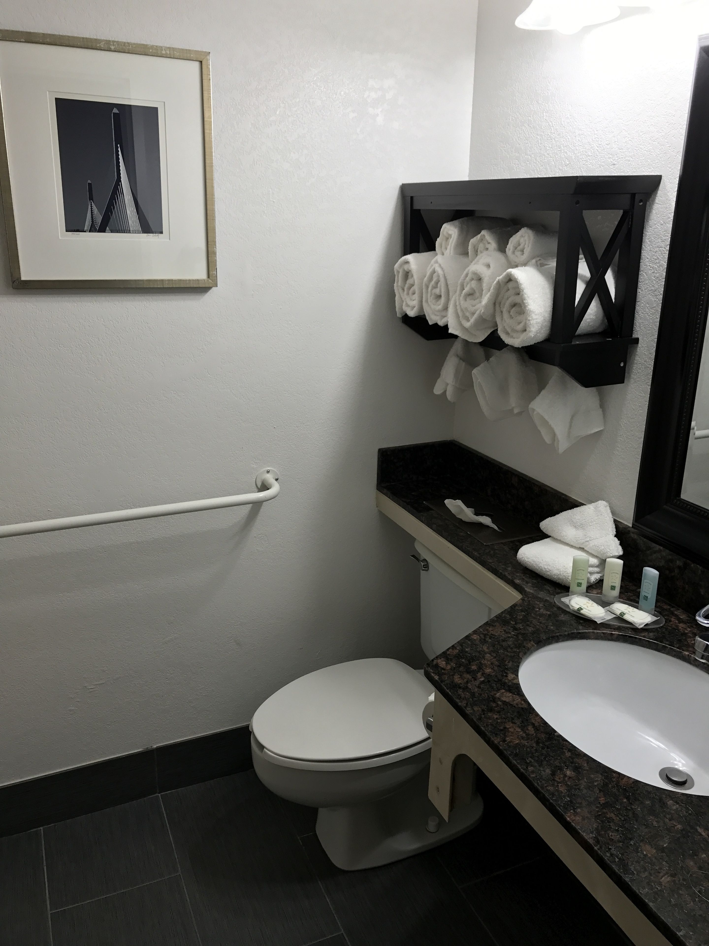 Un baño pequeño con inodoro, lavamanos y toallero.