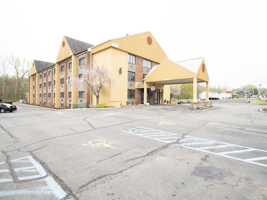 A multi-story hotel with a yellow facade and a covered entrance.
