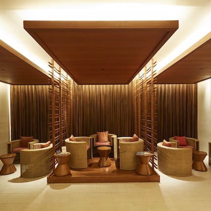 A modern lounge area with wicker furniture and a central seating arrangement.