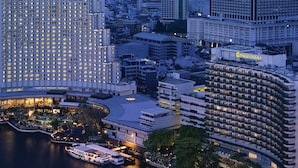 A high-rise hotel with multiple floors, a waterfront location, and a pool area.