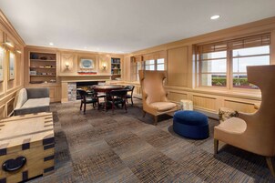 A spacious room with a fireplace, a dining table, and comfortable seating.