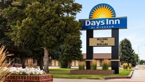 Placa da Days Inn com um logotipo de sol, dando as boas-vindas aos hóspedes do hotel.