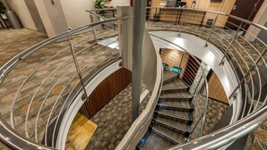 A spiral staircase with metal railings and carpeted steps. - Holiday Inn Perth City Centre by IHG (Perth)