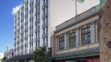 Un hôtel Holiday Inn doté d’une façade moderne, de grandes fenêtres et d’un logo vert bien visible.