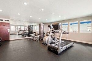 Una palestra con tapis roulant, ellittiche e attrezzature per pesi.