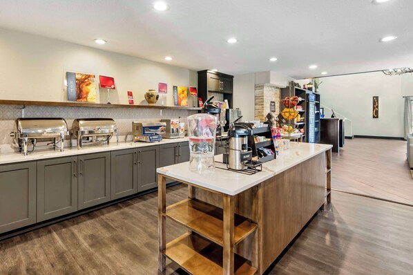 A modern kitchen with a central island, built-in appliances, and a variety of food items on the counter.