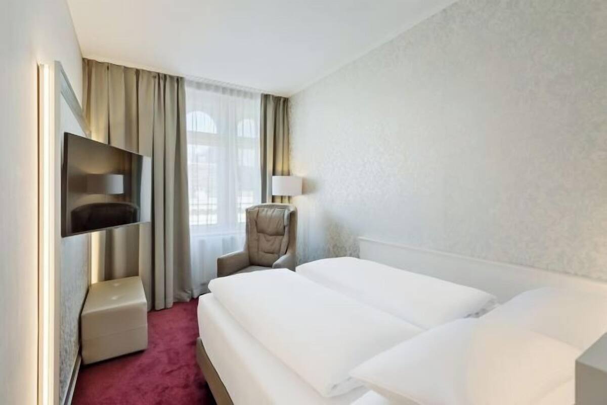 Luxe beddengoed, een kluis op de kamer, een bureau, een laptopwerkplek