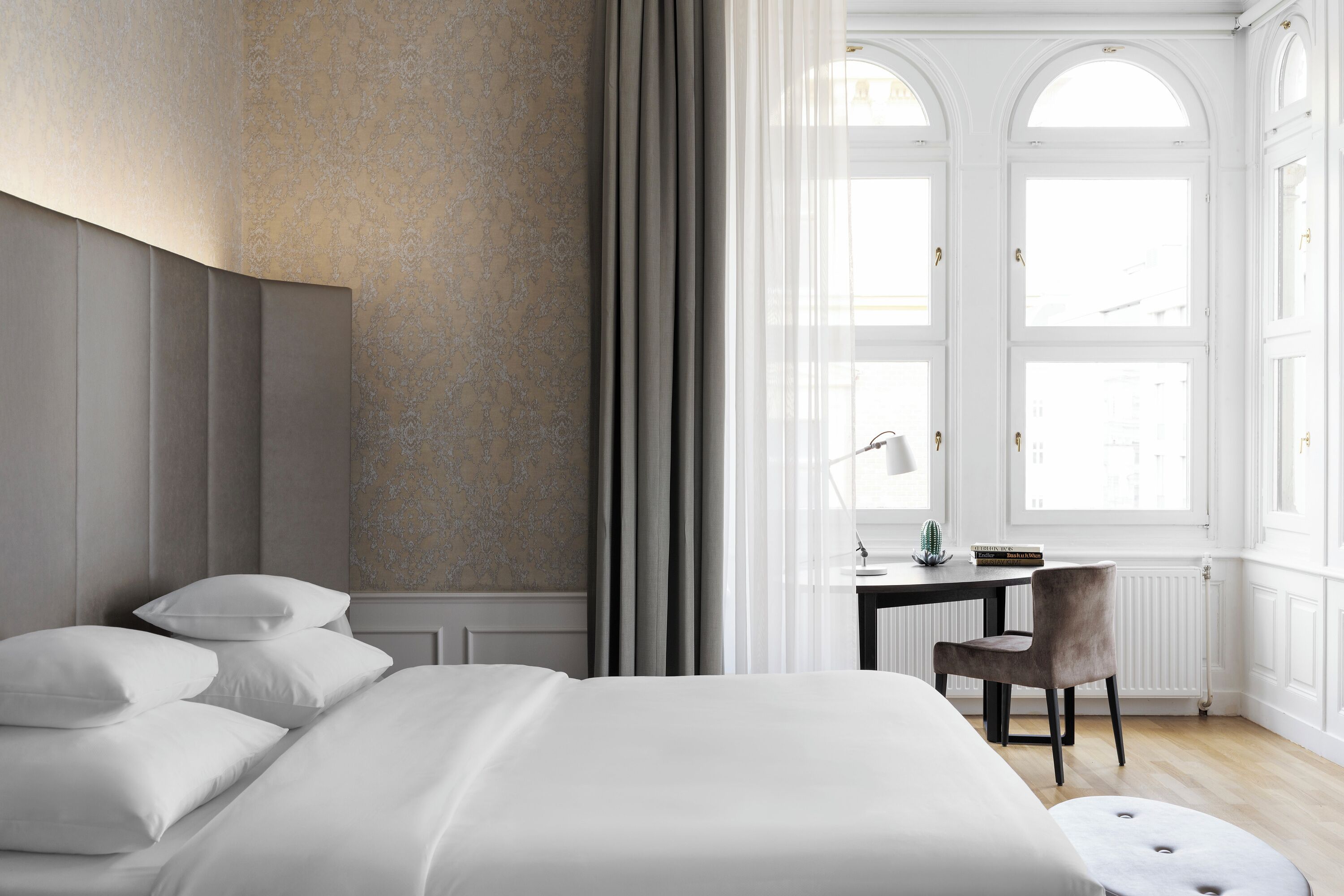 Una camera da letto moderna con un letto grande, una scrivania e una sedia.