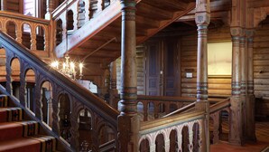 A grand staircase with ornate railings and multiple levels, leading to a room with wooden walls and a chandelier. - Scandic Holmenkollen Park (Oslo)