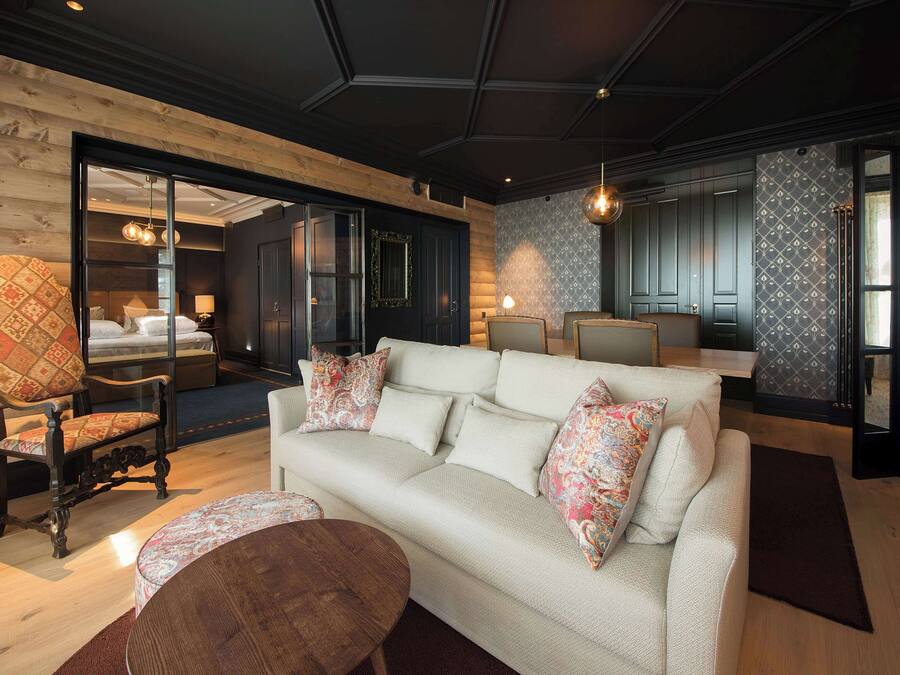 A modern living room with a sofa, armchairs, and a coffee table.