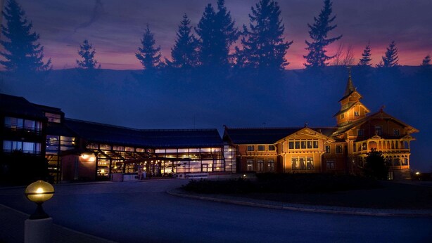 A large building with multiple sections, including a prominent tower with a spire. - Scandic Holmenkollen Park (Oslo)