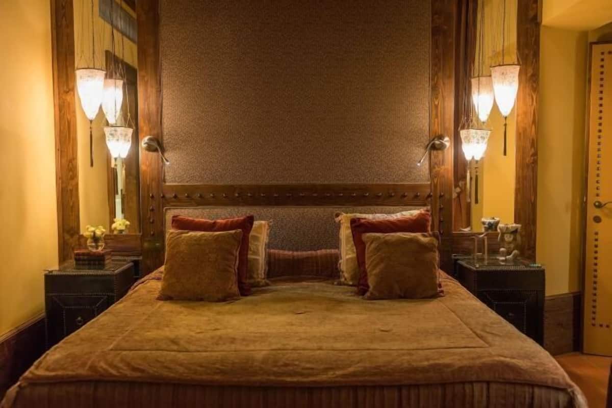 Ein Bett mit Holz-Kopfteil, zwei Nachttische und Wandlampen.