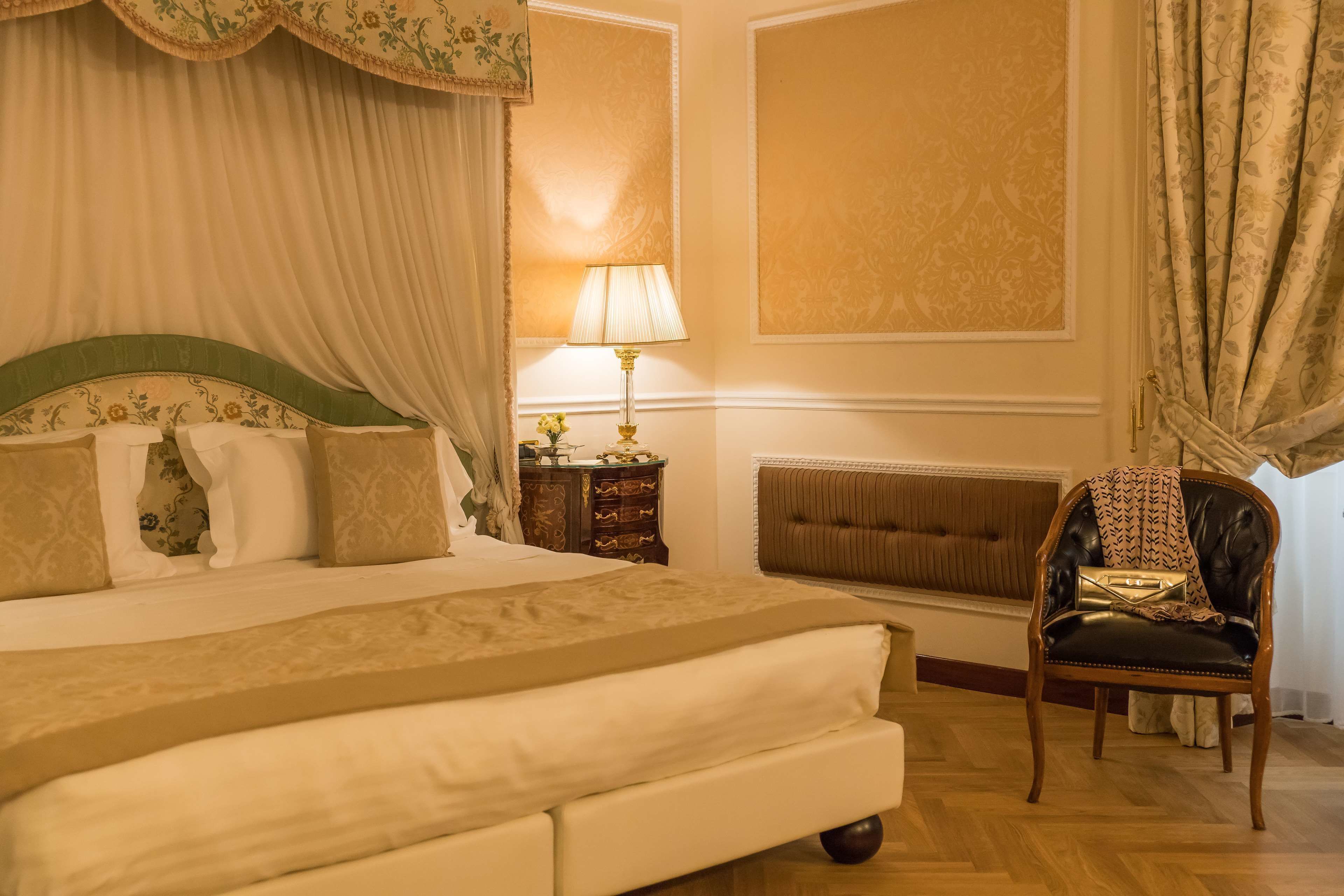 Una camera da letto curata con un letto grande, un comodino, una sedia e una lampada.