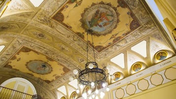 Eine kunstvolle Decke mit aufwendigen Verzierungen und einem Kronleuchter.