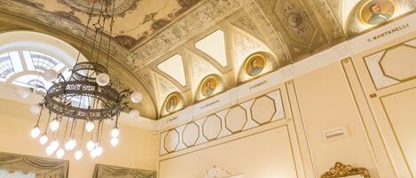 An ornate ceiling with intricate designs and a chandelier.