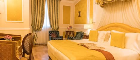 Una habitación de hotel con una cama grande, una zona de estar con una mesa y sillas, y un candelabro.