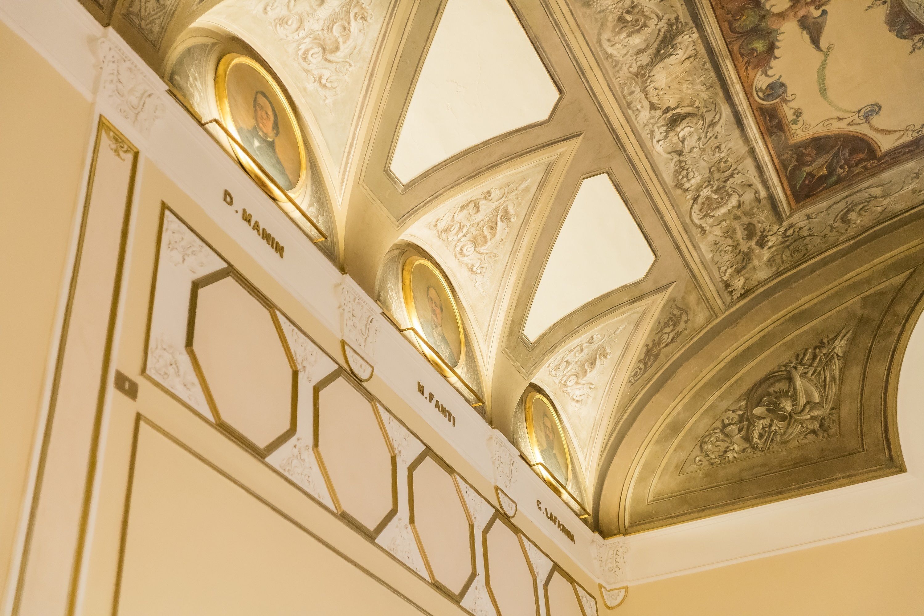 Un soffitto con decorazioni dorate elaborate e motivi geometrici.