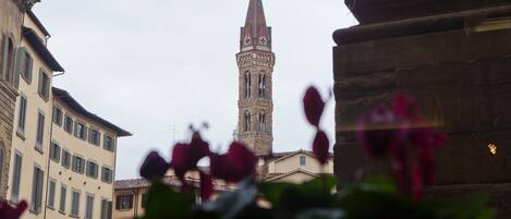 A historic building with a prominent tower, surrounded by other structures.