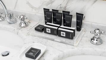 A bathroom with a marble countertop, a sink, and a mirror. There are several black boxes and tubes labeled "CULTI" on the countertop.