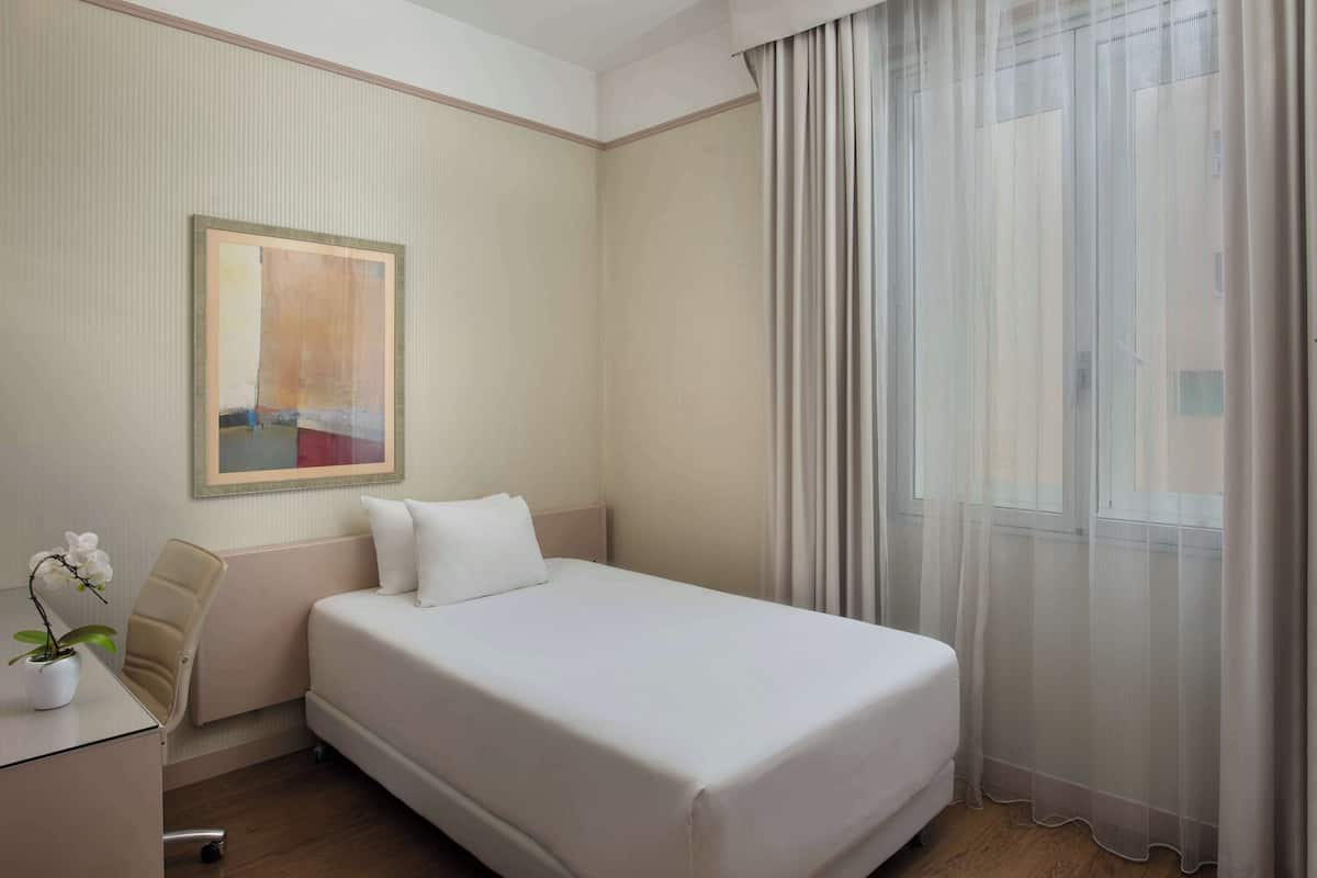 Standaard eenpersoonskamer | Een minibar, een kluis op de kamer, een bureau, een laptopwerkplek