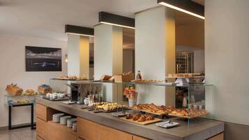 Un espace buffet où diverses préparations culinaires sont présentées sur des comptoirs et des étagères en verre.