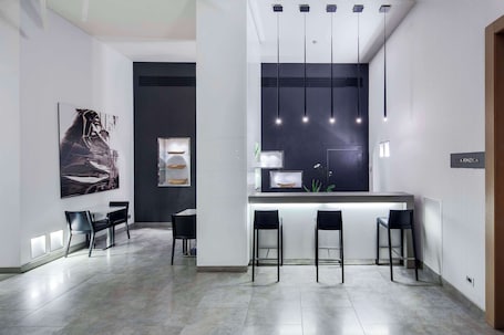 A modern kitchen with a central island, bar stools, pendant lighting, and a large framed artwork on the wall.