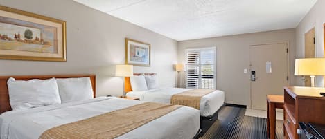 Una habitación de hotel con dos camas, un escritorio y una cómoda.